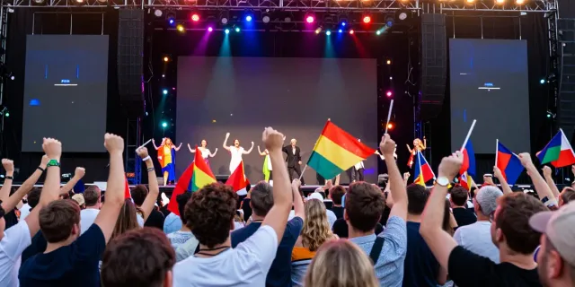 Eurovision semi-final celebration with diverse audience enjoying the vibrant performances at KurPramogauti.